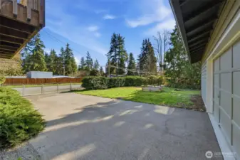 Detached garage/shop featuring its own paved, fenced entrance for added convenience and accessibility.