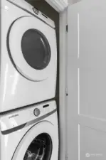 A convenient in-unit laundry area featuring a modern stacked washer and dryer for efficient living.