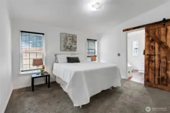 Primary bedroom with sliding barn door to primary bath