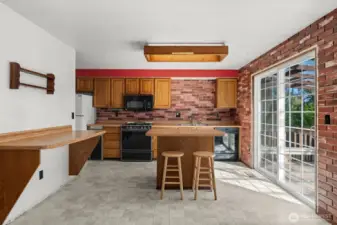 The kitchen showcases a central island with direct access to the covered deck, creating an ideal space for entertaining in any season.