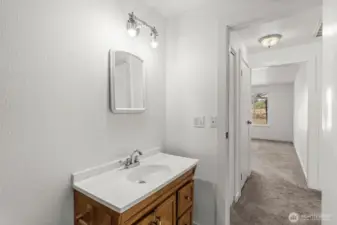 The main-floor bathroom features a fiberglass standing shower with a low-curb entrance, designed for easy accessibility.