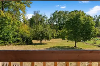 Step onto the covered backyard deck with sweeping views of the just shy of a half-acre yard — the perfect place to entertain guests rain or shine, and a true extension of the home’s living space.