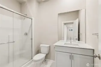 3/4 bathroom on main level featuring a large walk-in shower with frameless glass sliding door. Photos are representative only and may display different color package and/or upgrades.