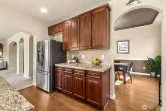 Well-appointed built-in cabinetry with granite surfaces offers a stylish and functional space for a coffee bar, serving area, or additional prep.
