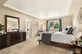 Beautifully appointed primary suite with attached bath and serene backyard views overlooking the lush, landscaped grounds.