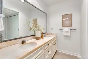 Double vanity with separate toilet closet with shower.