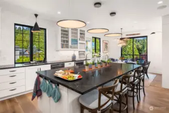 The kitchen features counter-to-ceiling designer tile, a wine cooler, a beverage bar, and exquisite Flemish glass cabinets, combining style and functionality.