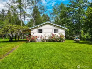 Carport next to cabin with westeria.