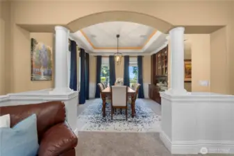 Columns & wainscoting lead into the formal dining w/built-ins, surround sound, coffered ceiling w/double crown molding & accent lighting.  New drop down light fixture.