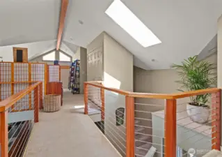 Loft hallway as you walk away from the primary suite. Laundry closet on the right side.