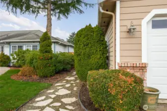 Mature landscaping and stone path from front to back.