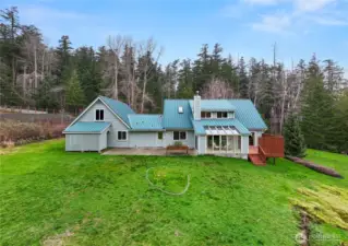 Spacious, level backyard that gently rolls into surrounding greenery, seamlessly blending with the adjacent forest lands for a peaceful, natural setting.