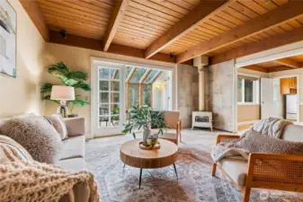 Another angle of the living room featuring the stand-alone wood fireplace, perfect for cozy winter evenings while enjoying the quiet of the surrounding nature.