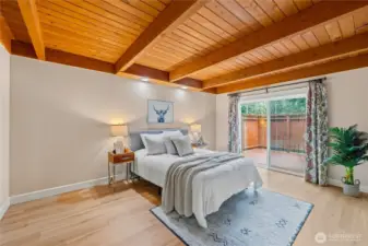 Main-level bedroom with beautiful wood ceilings and direct access to a private deck, creating a quiet retreat within the home.