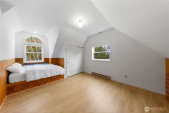 Upper-level bedroom featuring a custom built-in bed with drawers for extra storage, a spacious closet, and additional built-in drawer space along the walls, making the most of every inch.