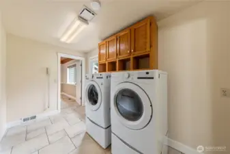 Conveniently located between the main home and the attached office, the laundry room serves as a functional everyday hub. It includes a half bathroom with an industrial-grade utility sink, ideal for cleaning paint brushes, gardening tools, or everyday messes, and offers direct access to the backyard for added convenience.