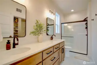 Primary ensuite with walk-in shower, dual vanities, and walk-in closet