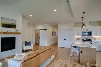 Cozy gas fireplace and barn door into laundry room and garage. Laundry room has wash basin and storage closet