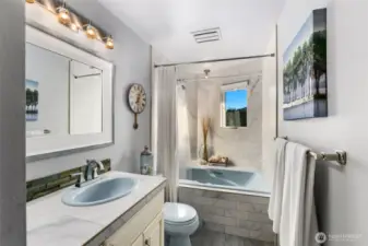 Full bathroom w/garden tub surrounded by floor to ceiling tile.