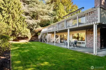 The home’s broad deck and lower patio embrace the lush backyard - an open invitation for morning coffee, good times, and long summer evenings.