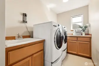Large upstairs laundry room (where the bedrooms are!) includes ample storage space, folding counter & sink.