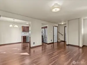 Great room showing dining & stairs by garage entry