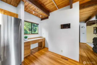 Built-in desk area is conveniently located in the far end of the kitchen, just around the corner from the entry.