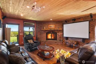 Light-filled living space anchored by a dramatic stone fireplace.
