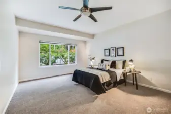 Let's continue our tour back inside! The primary suite is a spacious retreat overlooking the greenbelt. Its grand size can easily hold a king size bed and full furniture ensemble.