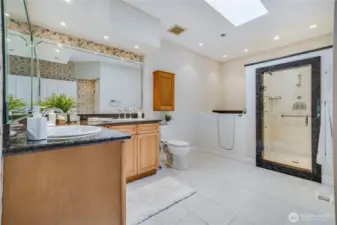 Featuring a tile floor, high end installations, and a generous vanity, the primary suite bathroom has many wonderful features.