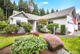 Imagine coming home to this picturesque setting! Mature landscaping surrounds the home, and the rhododendrons are beautiful in the spring.