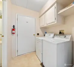 Laundry room with overhead storage.