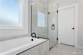 Large, tiled shower with a large soaking tub.