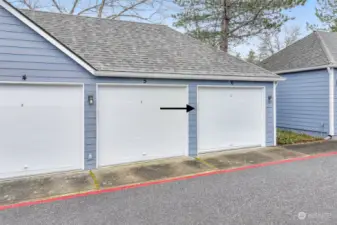 A private garage with a secure roll-up door, offering protected parking and additional storage space.