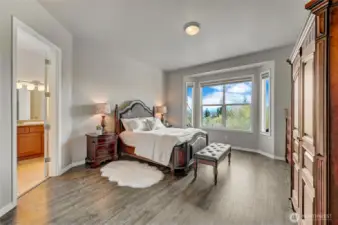 The primary bedroom looks out to the golf course and mountain views. Newer Luxury Vinyl Plank flooring.