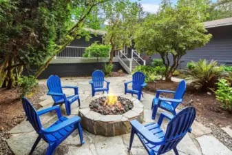 Effortless ambiance with gas-lit fire pit and tranquil outdoor setting.