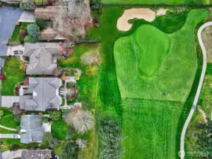 Set on a 10,000 SF corner lot, the Fairway Residence and Fairway Bungalow sit behind a mature yew hedge that grants privacy while opening to an expansive outlook across the sculpted 4th Green at Sand Point Country Club.