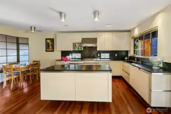 The Snaidero kitchen, designed by Renzo Piano, reflects the clarity and craft seen in his architectural work on the Centre Pompidou in Paris, the Menil Collection in Houston and the Whitney Museum expansion in New York. Sleek Italian cabinetry pairs with honed black-granite counters and custom metal detailing around the ventilation system. Dual Gaggenau convection ovens, a Smeg electric cooktop with downdraft vent and integrated Thermador refrigeration form a modern, efficient work zone set against radiant mahogany floors and natural light.