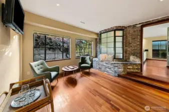 This quiet sitting area wrapped in stamped Venetian plaster steps down toward a wall of commercial steel windows that frame the courtyard garden. Just beyond is the 500 SF garage with its own set of large steel windows, dual radiant heaters and mechanical infrastructure. The space sits close to the utility room with terrazzo flooring, specialty tile and service systems that reflect the home’s thoughtful, well-crafted design.