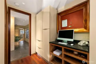 A built-in home-organization center sits just off the kitchen, with custom cabinetry designed to echo the clean lines of the Snaidero system. Honed black-granite counters, mahogany detailing and thoughtful storage create an efficient hub that connects the kitchen to the hallway and utility spaces.