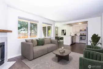 Bright, open living room with wide windows, neutral tones and flexible seating space.