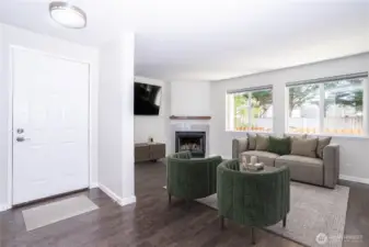 View from entry into the living room, showing open layout and bright windows.