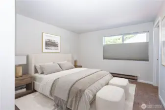 Primary bedroom with wide window and room for full-size furnishings.