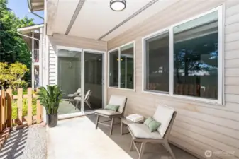 Covered patio with seating area and garden views.