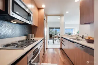 Stunning renovation of the kitchen with Caesarstone slab quartz countertops, Miele oven & dishwasher, Northland refrigerator, cool backsplash, stainless steel undermount sink with hot water dispenser, garbage disposal & wood cabinetry.