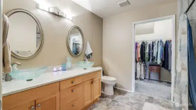 The primary bath has been updated with granite counters with a backsplash, new pedestal sinks, luxury vinyl and a spacious walk-in closet.