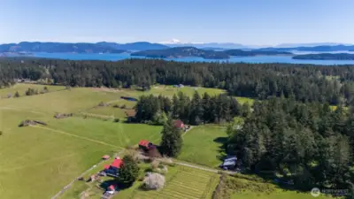 Aerial looking east toward Mt Baker. Twenty acres, multiple residences, barns, and outbuildings, pasture, forest, ponds, and territorial views in all directions