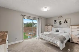 Primary bedroom with sliding door to small deck.