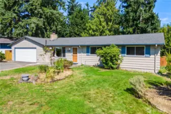 Side perspective highlights the fully fenced backyard access, extra green space, and mature landscaping. Ideal for gardeners, pet owners, or outdoor enthusiasts wanting both privacy and a low-maintenance outdoor retreat.