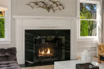 A dramatic fireplace surround paired with the home’s original 100-year-old mantel anchor this peaceful room.